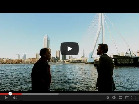 Beeld uit de promovideo van Struct4U: twee mannen in gesprek aan het water bij de Erasmusbrug in Rotterdam